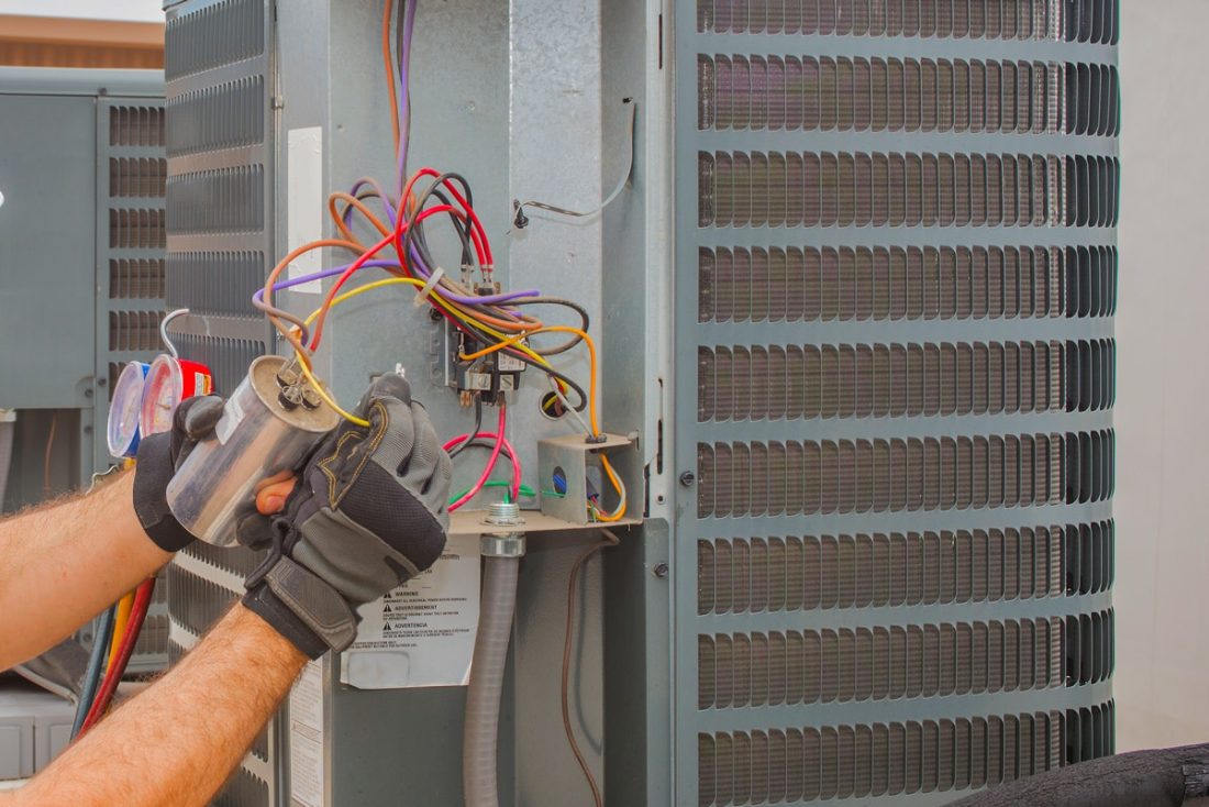 Hulgan technician repairing an air conditioner in Perry, Iowa