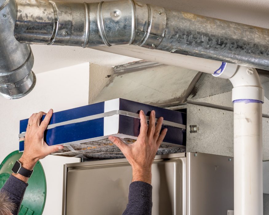 Installing a clean air filter in home ductwork to improve indoor air quality in Perry, Iowa